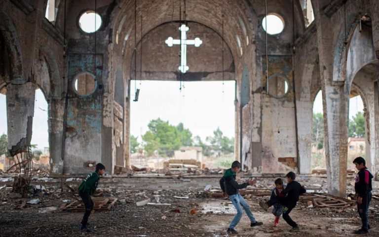Young boys play in ruins of a church